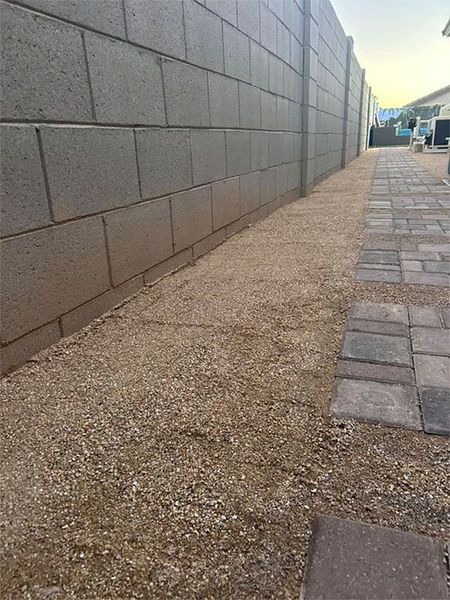 A sidewalk next to a brick wall and a brick walkway.