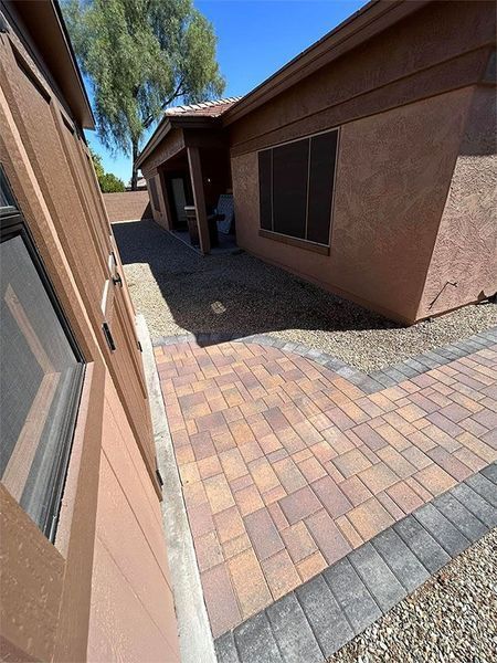 A house with a brick walkway leading to it.
