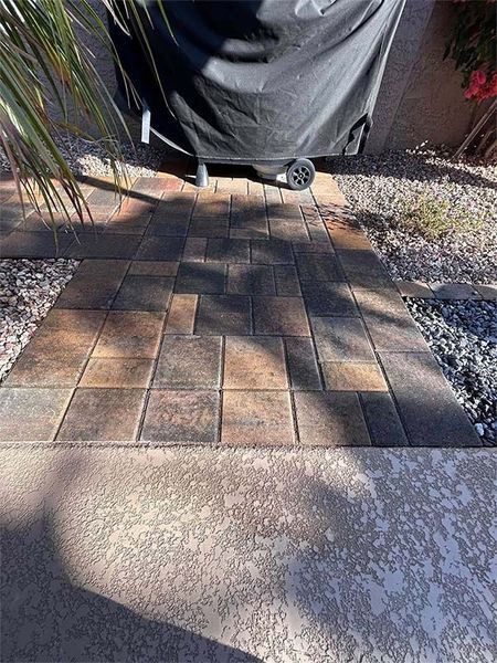 A brick walkway with a grill cover on top of it.