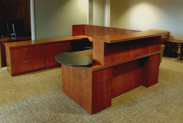 A wooden reception desk in a room with carpet
