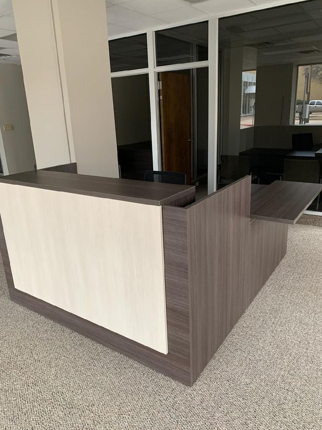 A reception desk in a room with a lot of windows.