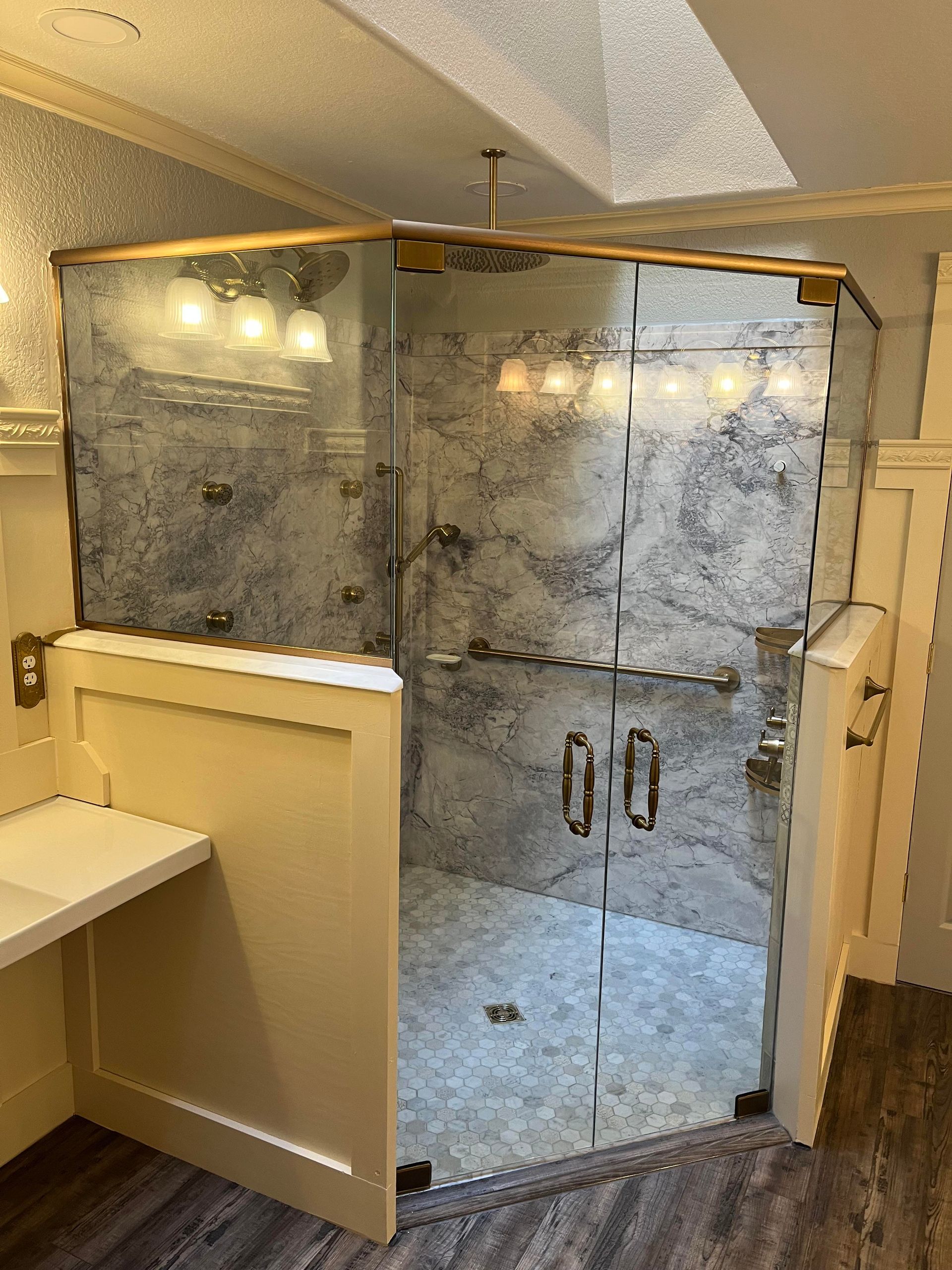 A bathroom with a walk in shower and a sink.