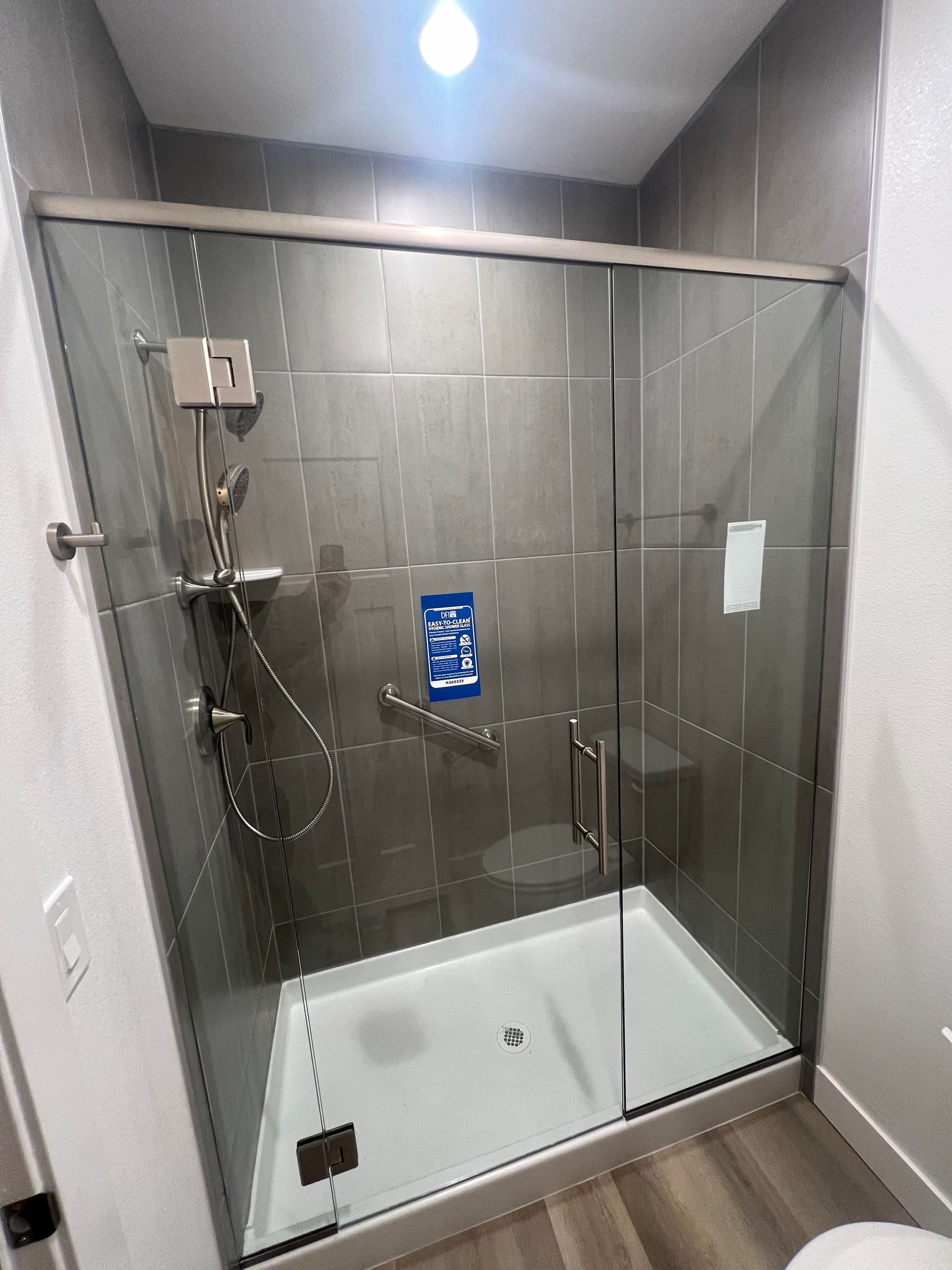 A bathroom with a sliding glass shower door and a toilet.