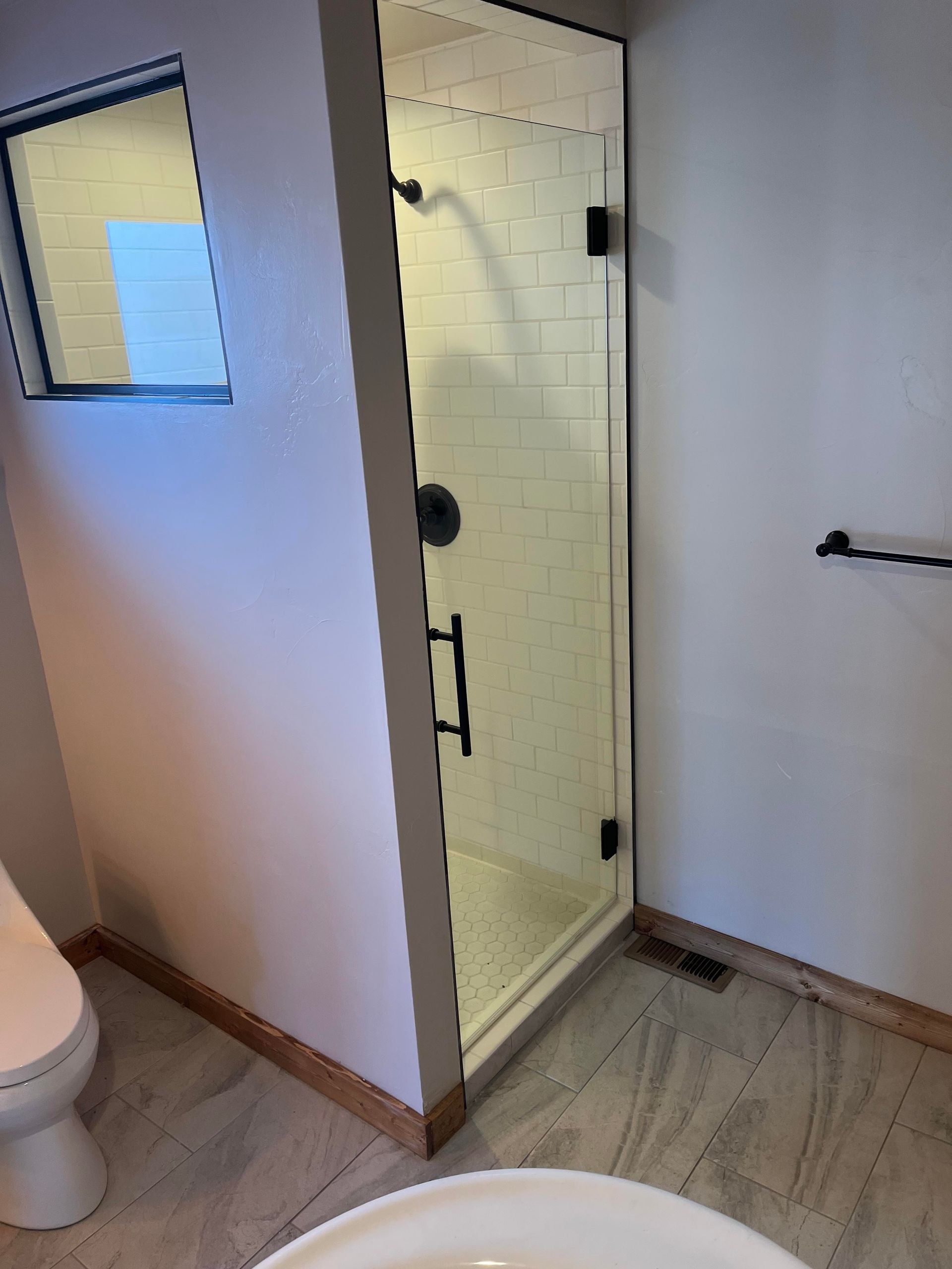 A bathroom with a toilet , sink and shower.