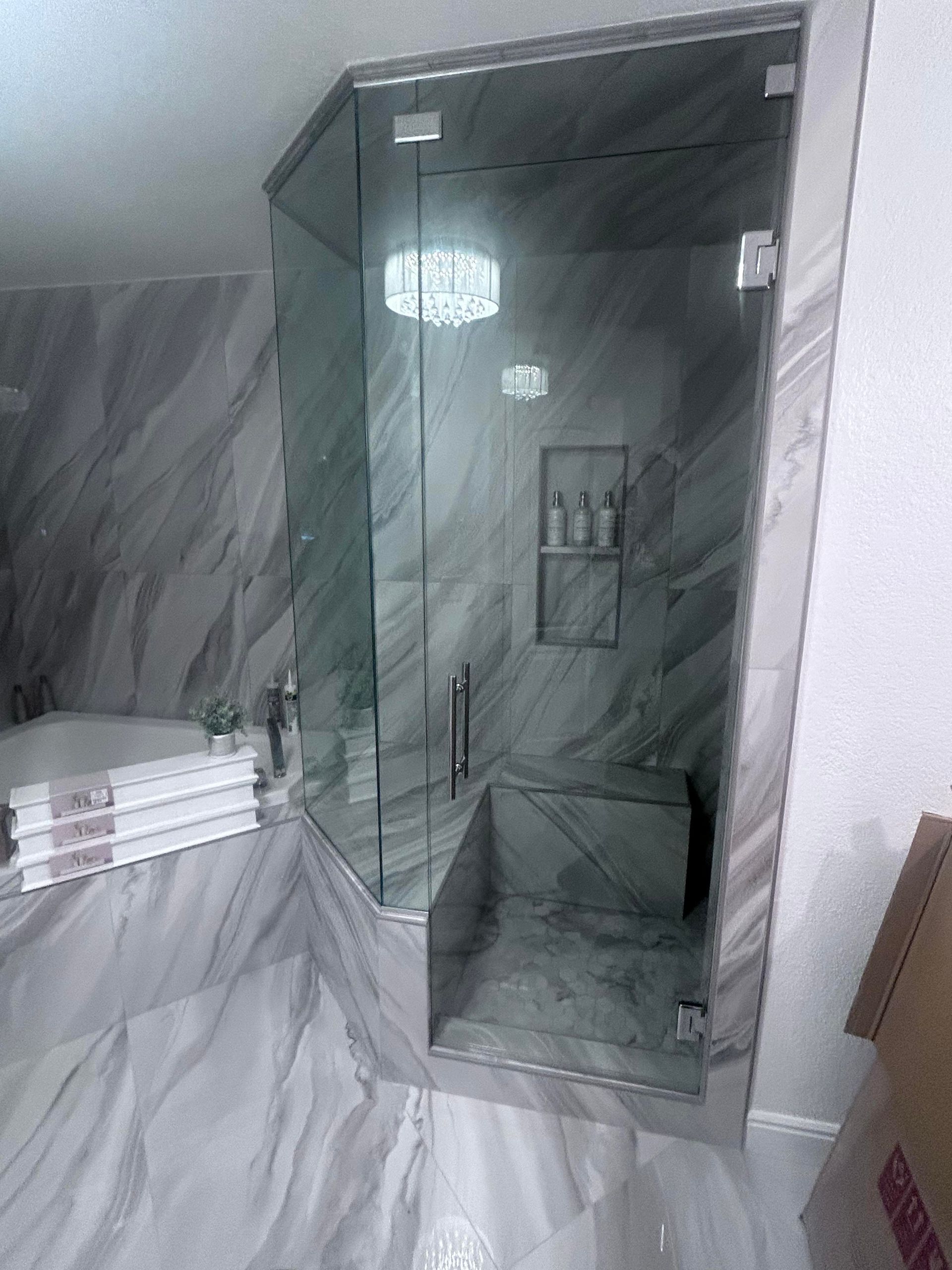 A bathroom with a glass shower door and a bathtub.