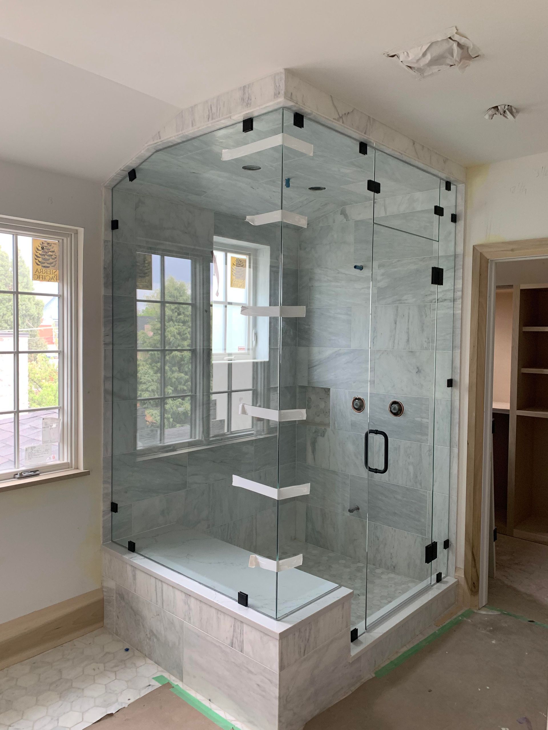 A bathroom with a glass shower door and a window.
