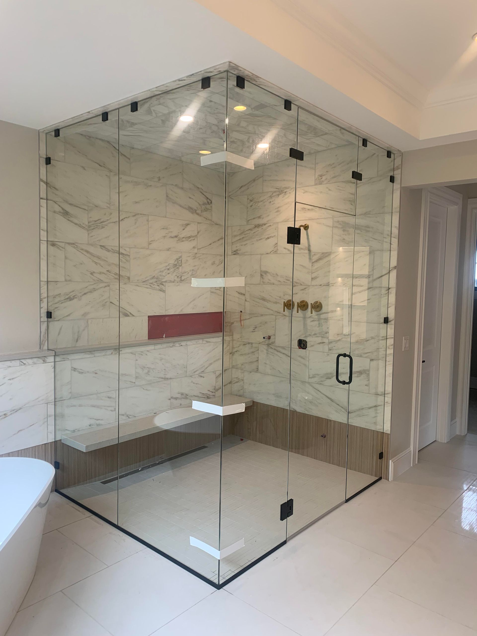 A bathroom with a walk in shower and a bathtub.