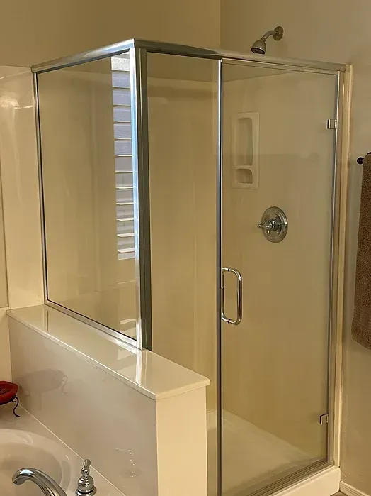 A bathroom with a glass shower stall and a sink.