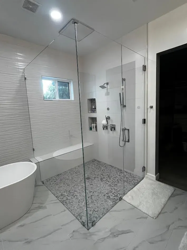 A bathroom with a walk in shower and a bathtub.