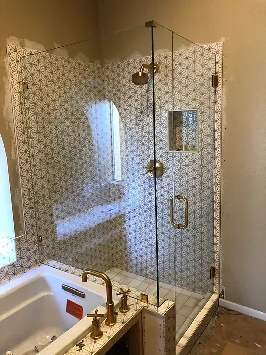 A bathroom with a tub and a shower with a glass door.