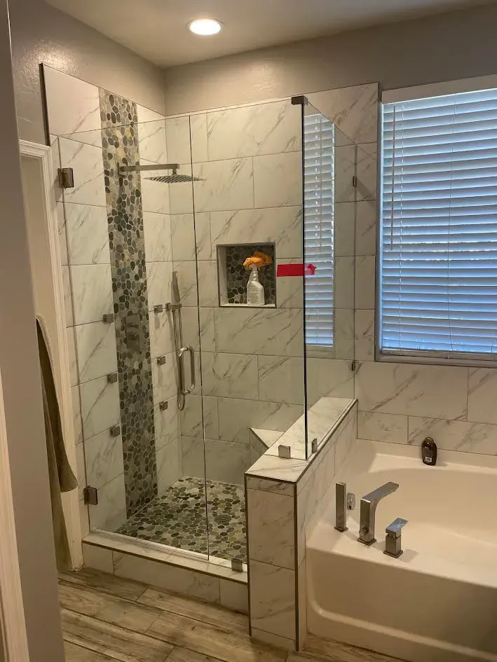 A bathroom with a walk in shower and a bathtub.