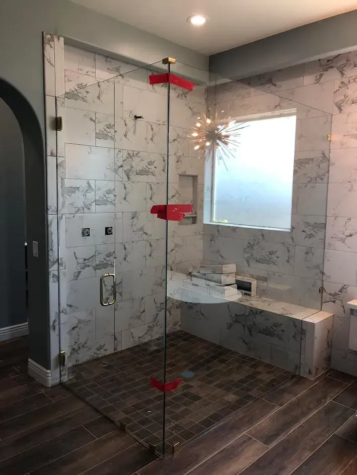 A bathroom with a walk in shower and a window.