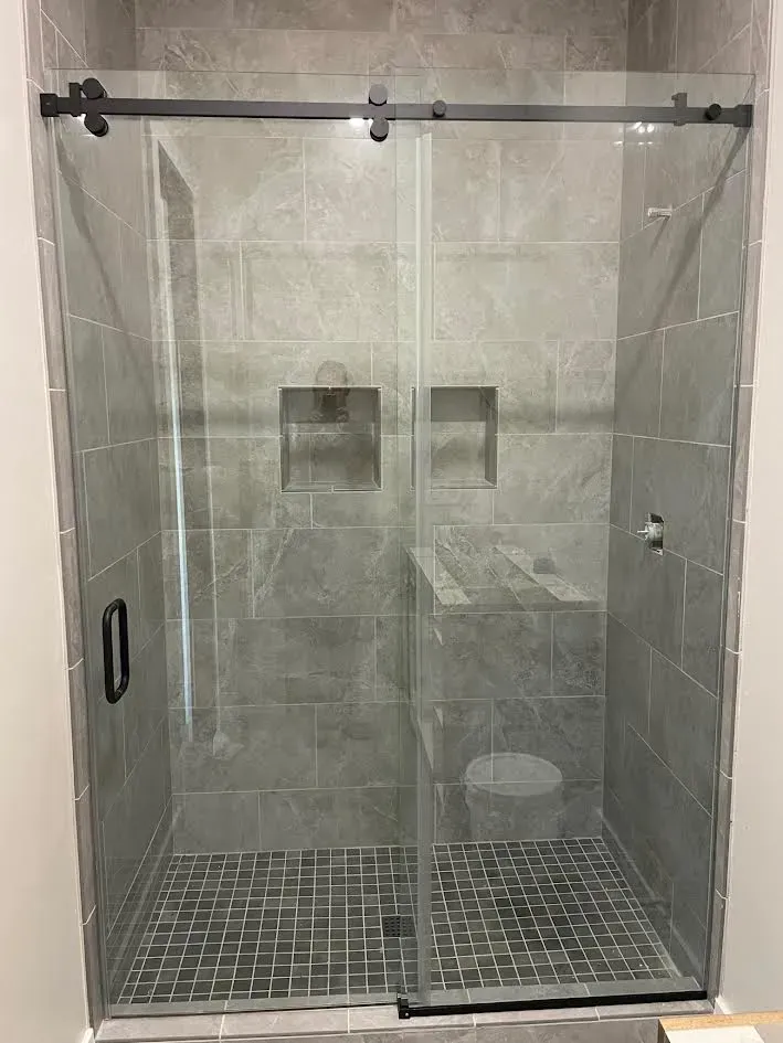 A bathroom with a sliding glass shower door and a toilet.
