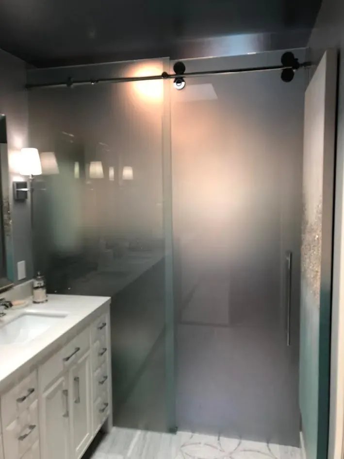 A bathroom with a sliding glass shower door and a sink.