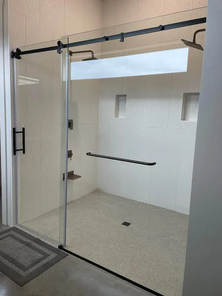 A bathroom with a sliding glass shower door and two shower heads.