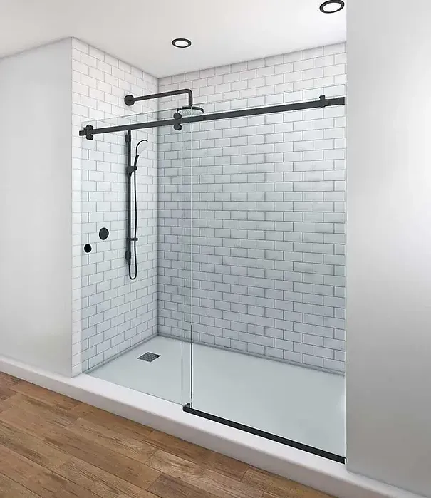A shower with a sliding glass door and white brick walls.