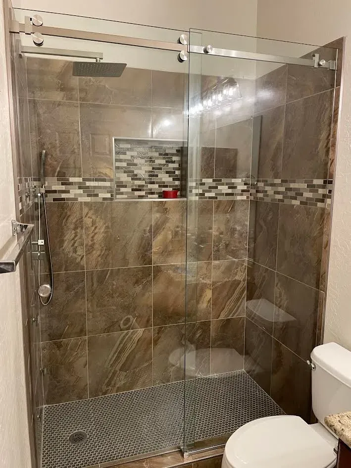 A bathroom with a sliding glass shower door and a toilet.