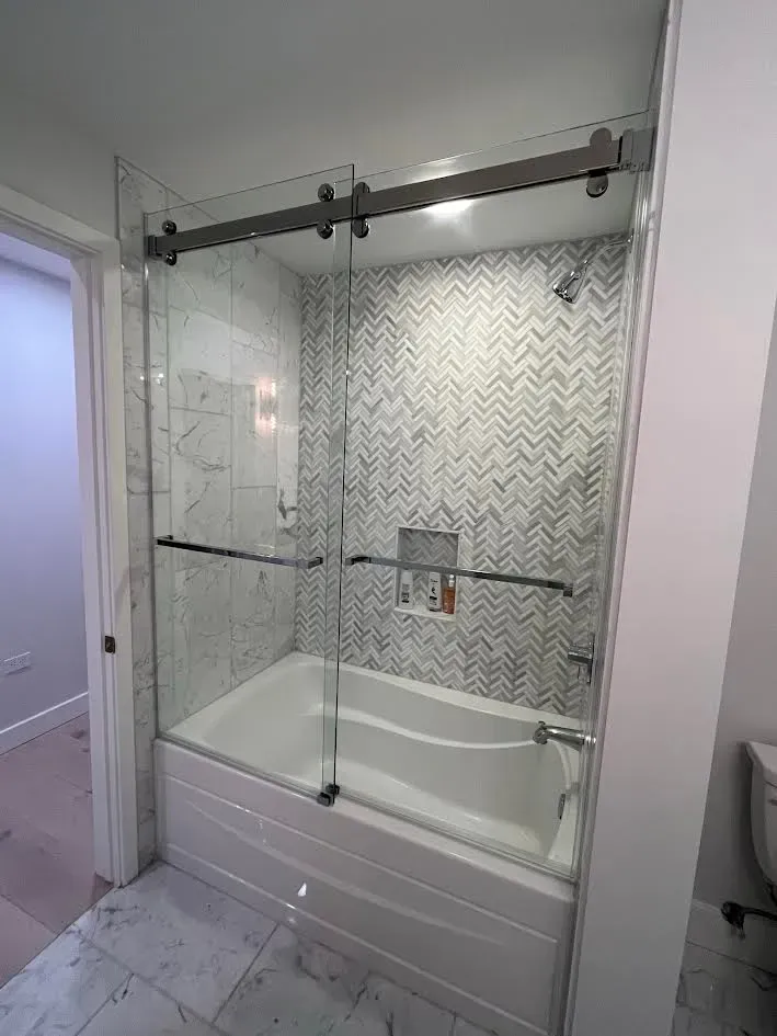 A bathroom with a bathtub and a sliding glass shower door.
