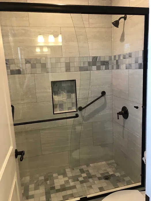 A bathroom with a sliding glass shower door and a toilet.