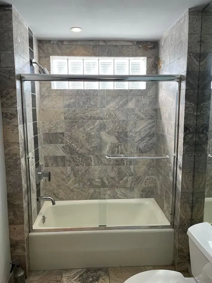 A bathroom with a bathtub , toilet and shower.