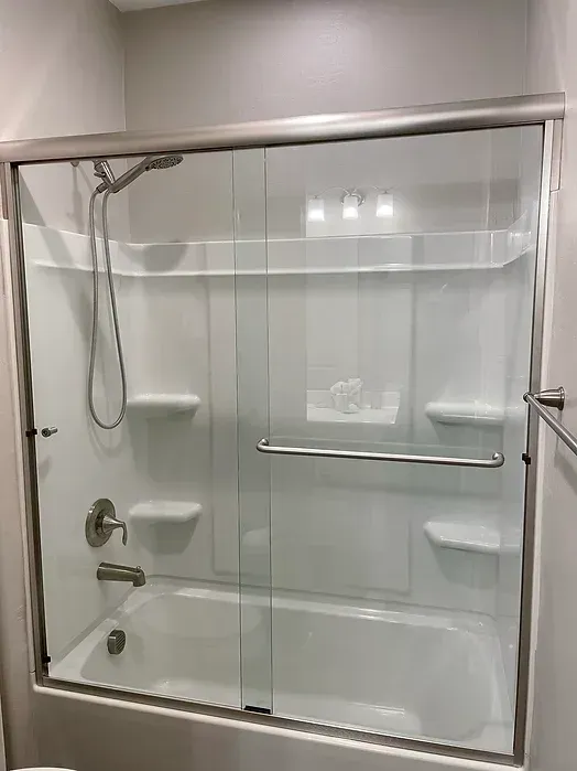 A bathroom with a bathtub , shower , and sliding glass door.