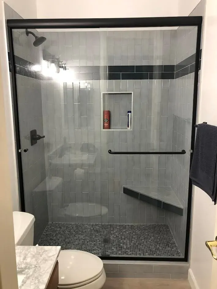 A bathroom with a sliding glass shower door , toilet , and sink.