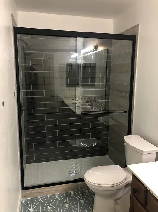 A bathroom with a toilet , sink and shower stall.