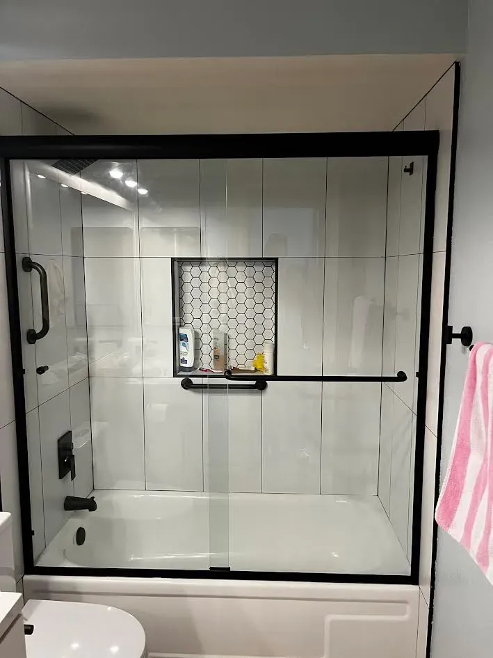 A bathroom with a bathtub and a sliding glass shower door.