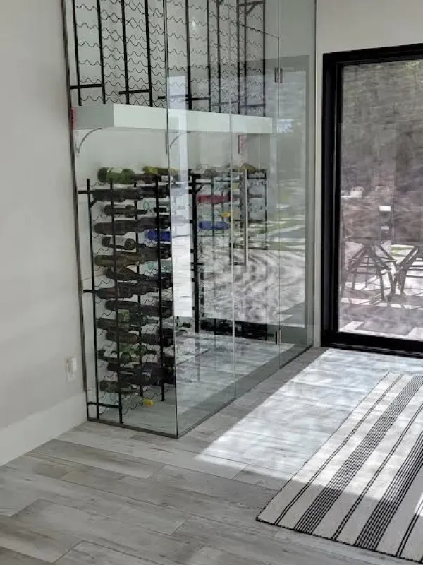 A wine cellar with a sliding glass door and a wine rack.