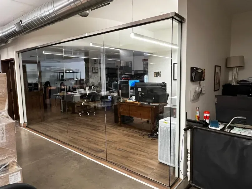 A room with a glass wall and a desk in it.