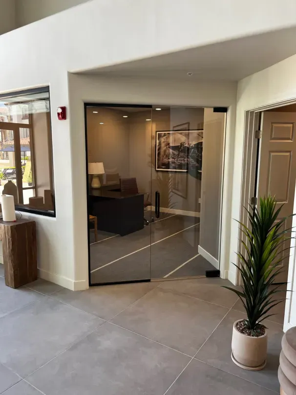 A living room with a sliding glass door and a potted plant.