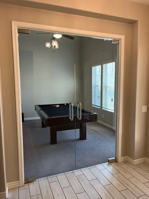 A pool table in a room with a glass door