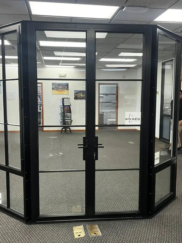 A room with a lot of windows and a black door.