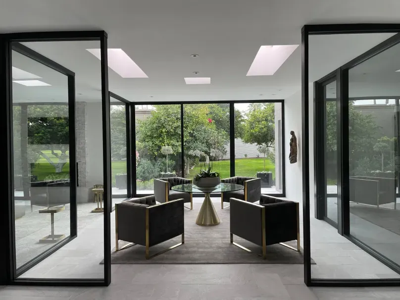 A living room with a lot of windows and chairs