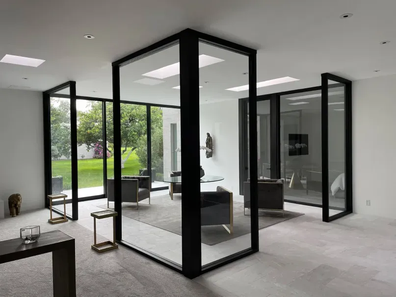 A living room with a lot of windows and chairs