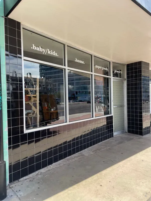 A store front with a lot of windows and a sign that says baby / kids