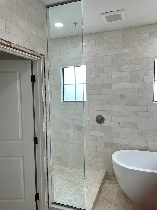A bathroom with a walk in shower and a bathtub.
