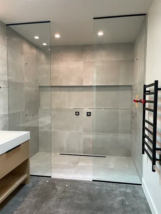 A bathroom with a walk in shower and a sink.