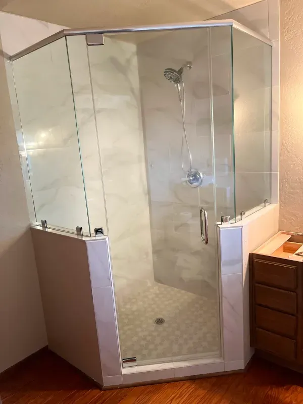 A bathroom with a sliding glass shower door and a shower head.