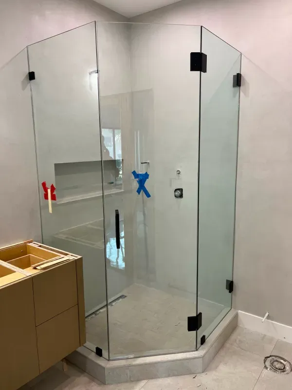 A bathroom with a glass shower stall and a sink.