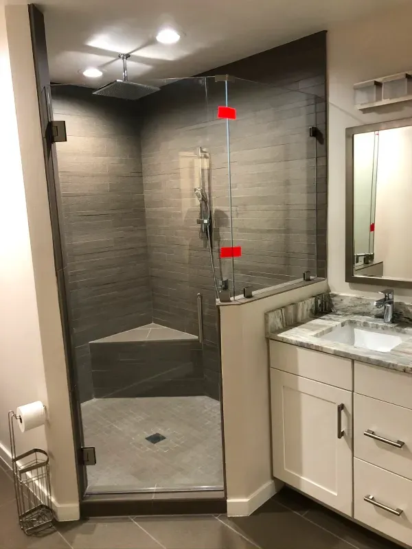 A bathroom with a walk in shower and a sink.