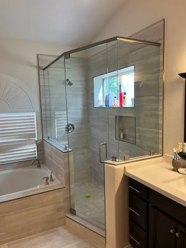A bathroom with a tub and a shower with a glass door.