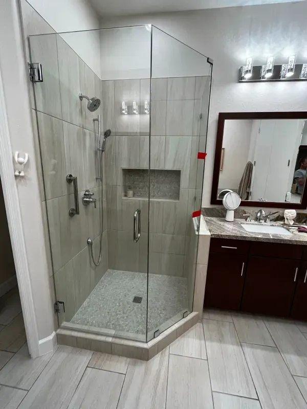 A bathroom with a walk in shower and a sink.