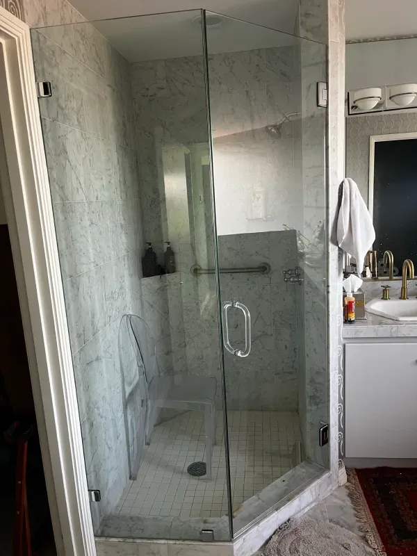 A bathroom with a walk in shower and a sink.
