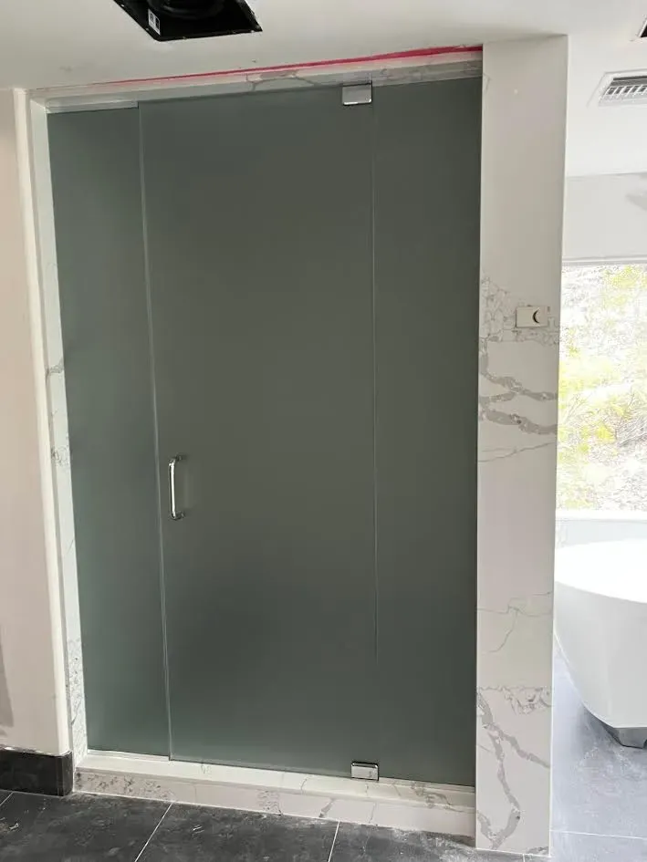 A bathroom with a sliding glass shower door and a bathtub.