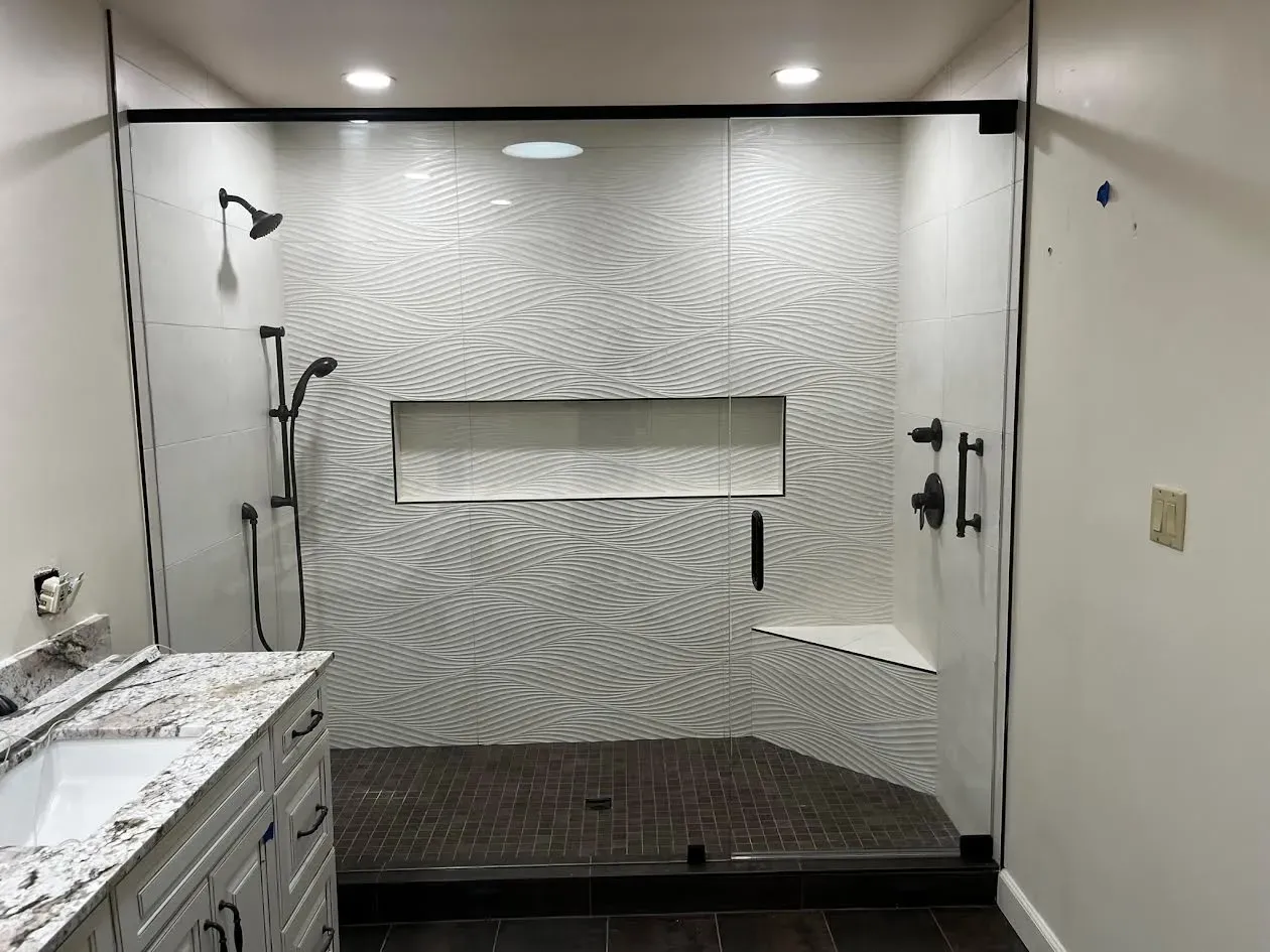 A bathroom with a walk in shower and a sink.