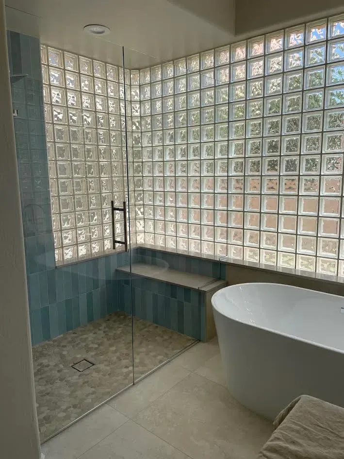 A bathroom with a walk in shower and a bathtub.