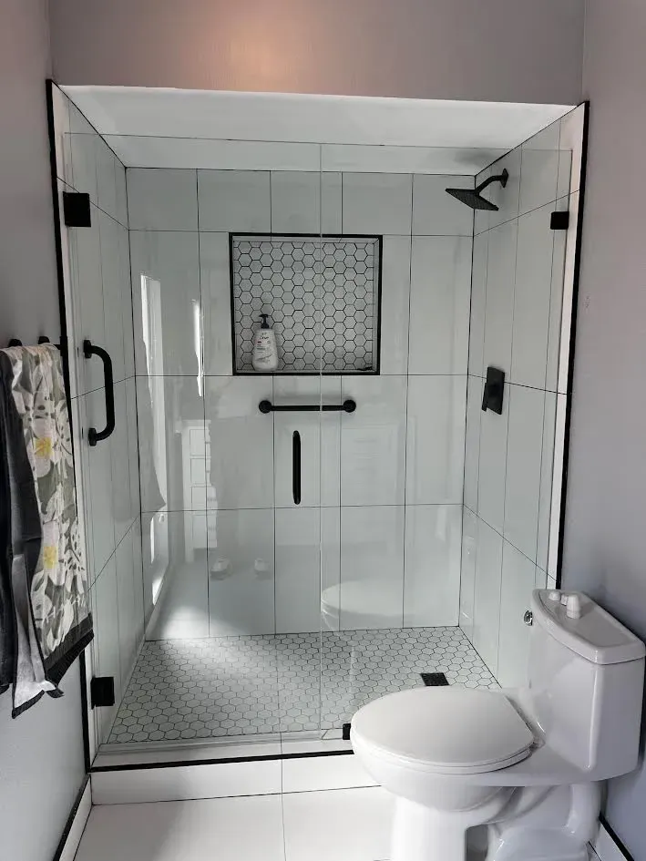 A bathroom with a toilet and a shower with a glass door.