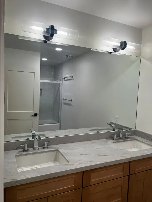 A bathroom with two sinks and a large mirror.