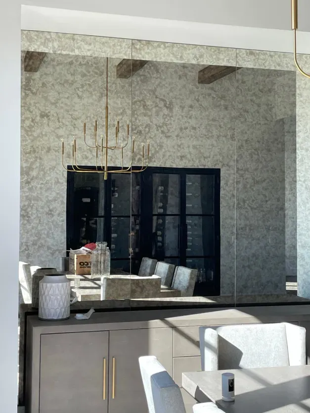 A dining room with a large mirror on the wall